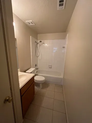 a bathroom with a granite countertop sink a toilet and shower