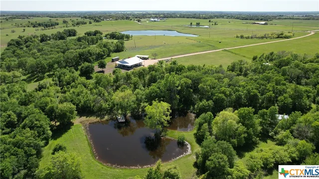 an aerial view of a houses with a yard and lake view