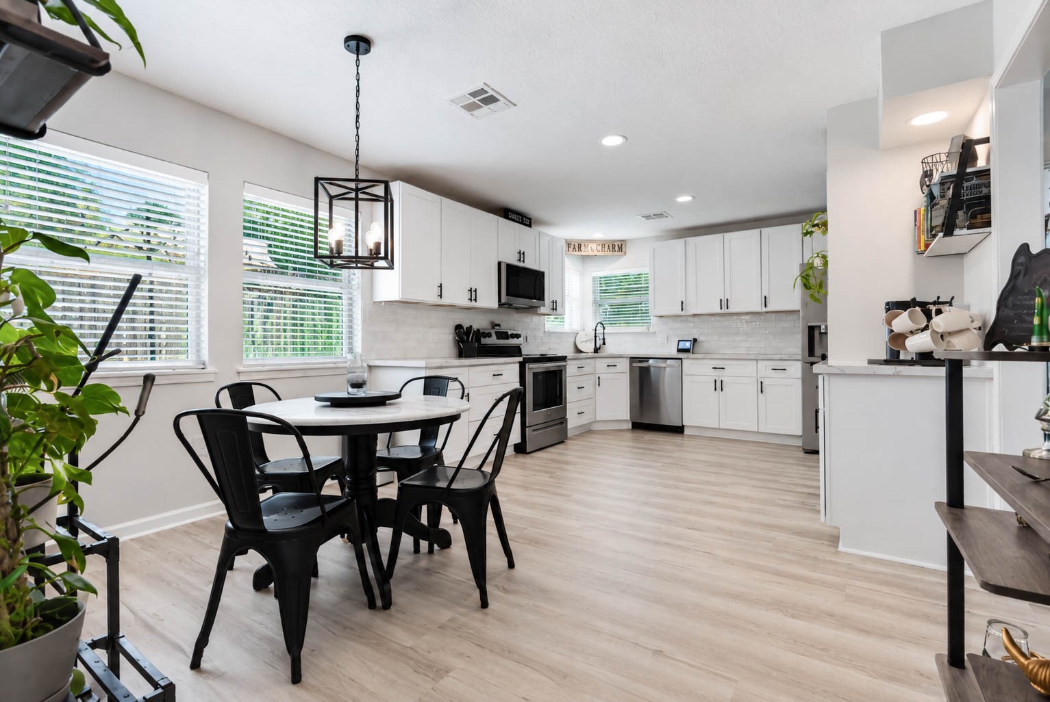 630 South Fry Road Katy, TX 77450 - Photo 14 of 48 Bright and spacious kitchen with modern white cabinetry, sleek stainless steel appliances, and a cozy dining area complemented by natural light and stylish fixtures.