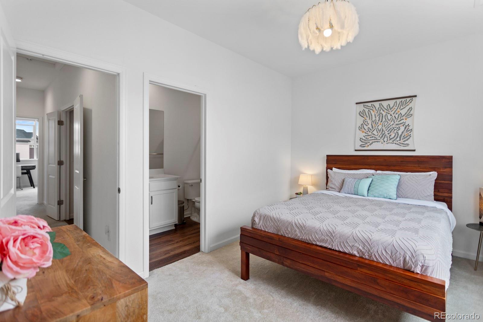 5105 Vivian Street Wheat Ridge, CO 80033 - Photo 15 of 39 a bedroom with a bed and a chandelier