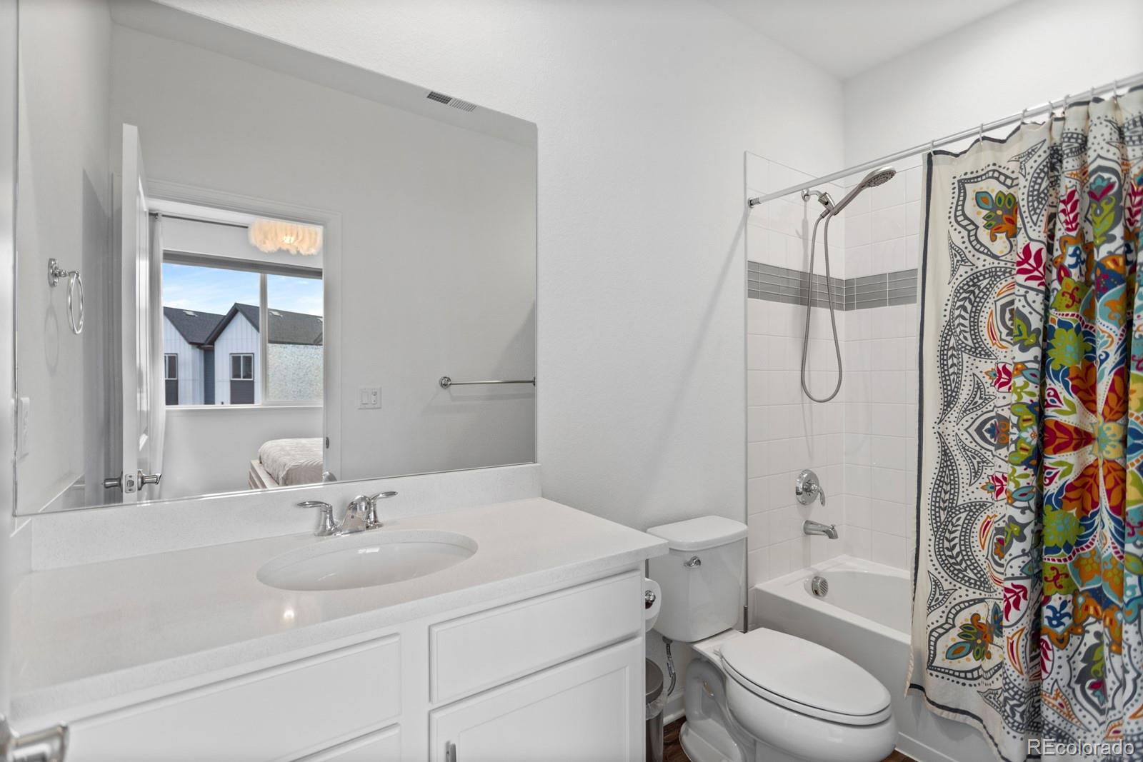 5105 Vivian Street Wheat Ridge, CO 80033 - Photo 19 of 39 a bathroom with a sink toilet a shower and a mirror