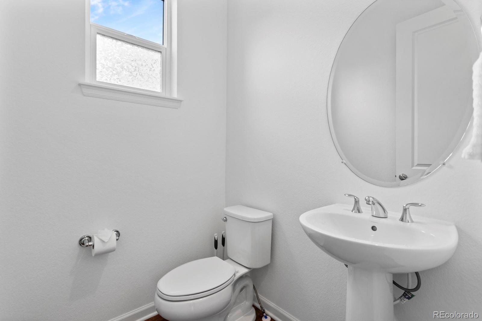 5105 Vivian Street Wheat Ridge, CO 80033 - Photo 22 of 39 a bathroom with a sink a toilet and a mirror