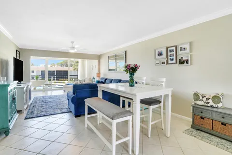 a kitchen with stainless steel appliances kitchen island granite countertop a table and chairs in it