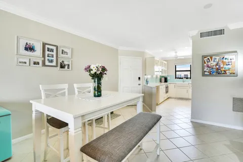 a view of a kitchen with kitchen island a table and chairs in it