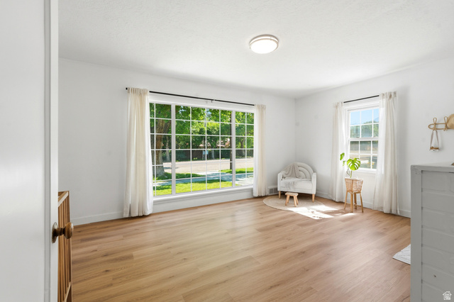 270 East 700 North Logan, UT 84321 - Photo 16 of 42 Bright room featuring wood-finish flooring, white walls, and a large multi-pane window