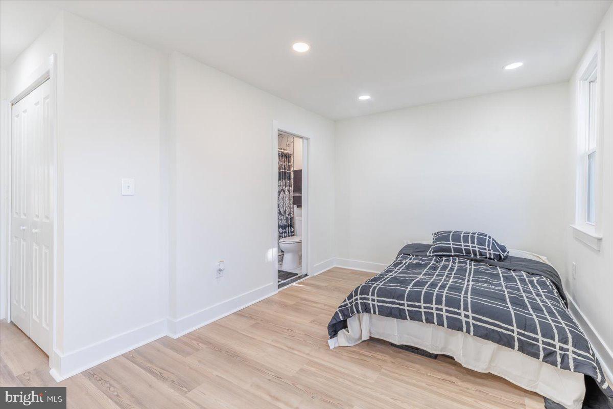 4702 Meade Street Northeast Washington, DC 20019 - Photo 26 of 28 a bedroom with a bed and wooden floor