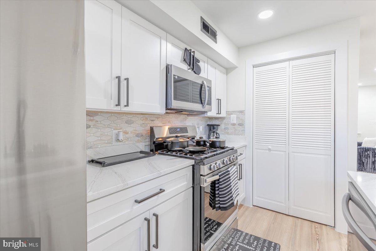 4702 Meade Street Northeast Washington, DC 20019 - Photo 9 of 28 a kitchen with stainless steel appliances granite countertop a stove and a sink