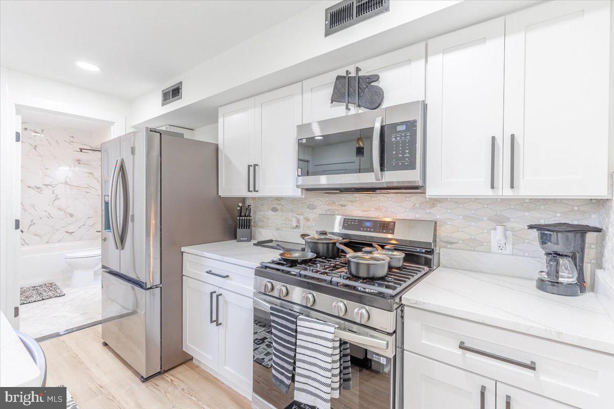 4702 Meade Street Northeast Washington, DC 20019 - Photo 10 of 28 a kitchen with stainless steel appliances a stove microwave and refrigerator