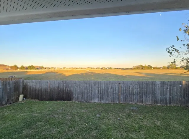 a view of a backyard with wooden fence