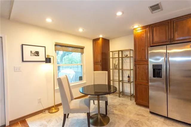 a kitchen with stainless steel appliances granite countertop a refrigerator a stove a microwave oven with a dining table and chairs