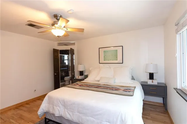 a spacious kitchen with stainless steel appliances granite countertop a stove a sink a dining table and chairs with wooden floor