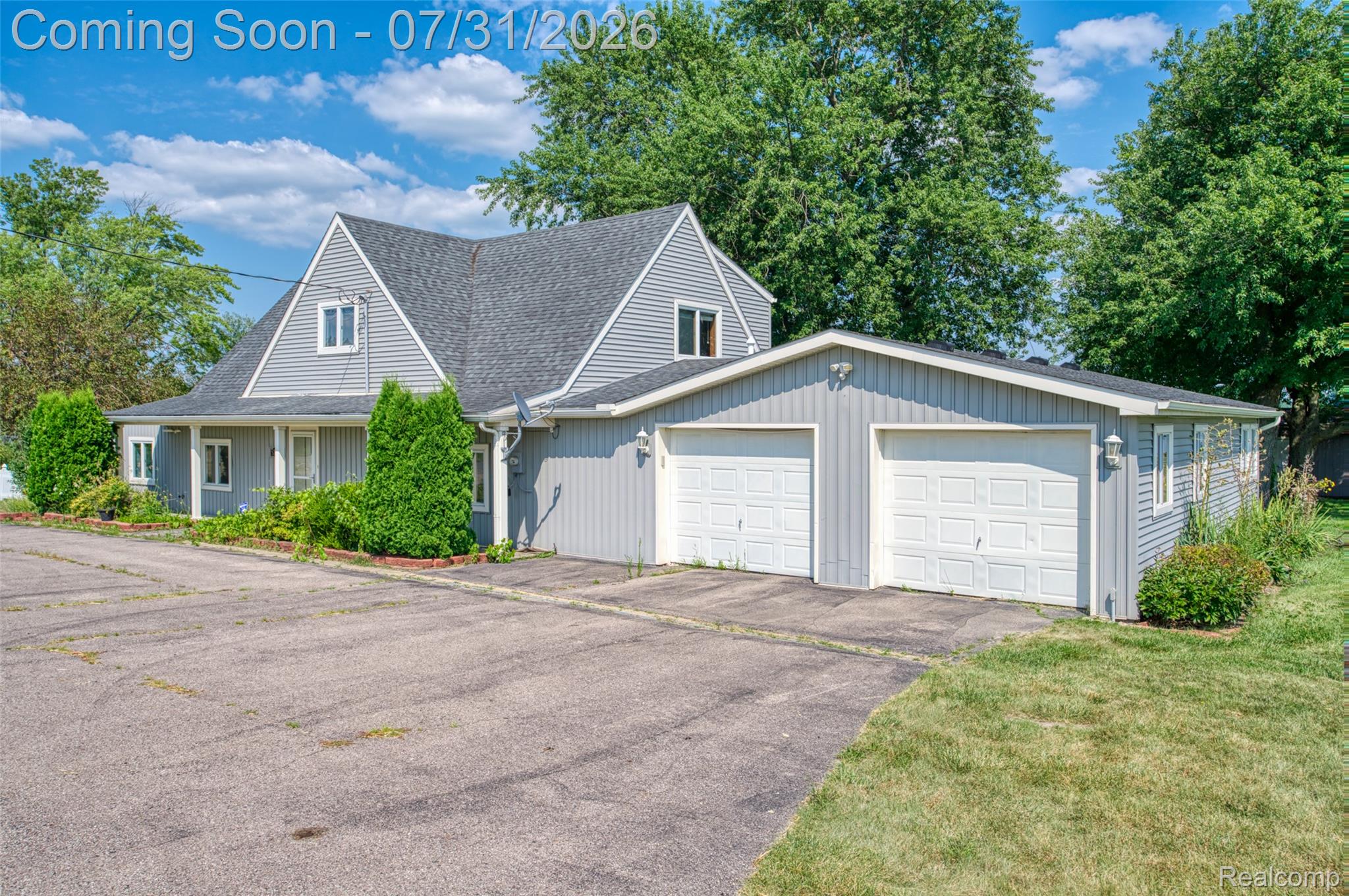 5269 Reno Road Manchester, MI 48158 - Photo 22 of 64 Siding exterior featuring a two-car garage with white paneled doors