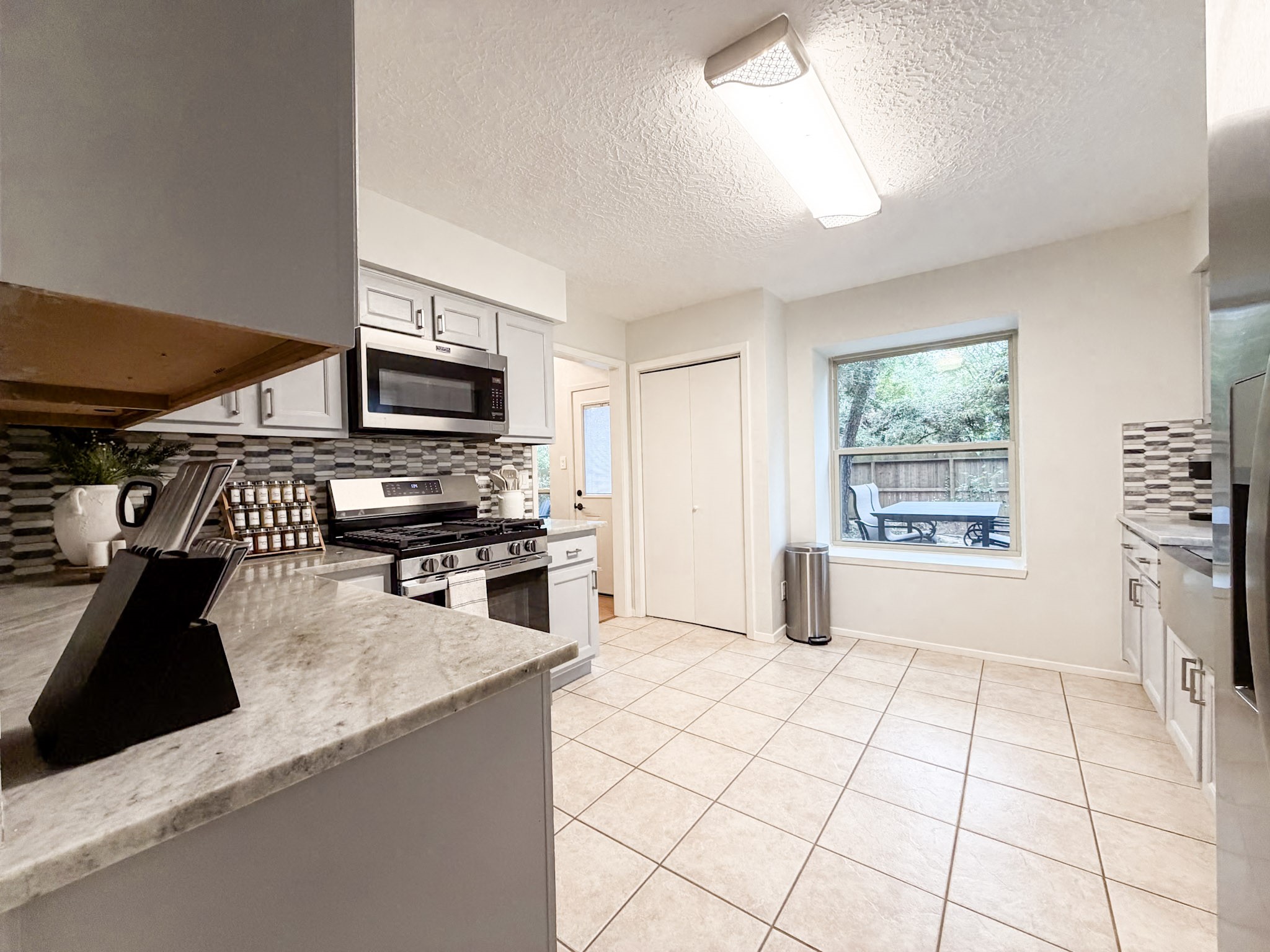29 Pinewood Forest Court Spring, TX 77381 - Photo 6 of 48 a kitchen with stainless steel appliances a stove a sink and a microwave