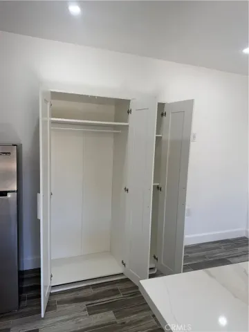 a view of a hallway with wooden floor and closet