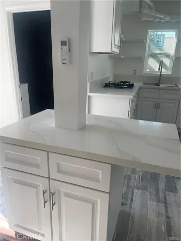 a kitchen with granite countertop white cabinets and black appliances