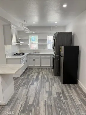 a view of a kitchen with wooden floor and a window