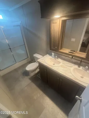 a bathroom with a granite countertop sink a toilet and a mirror