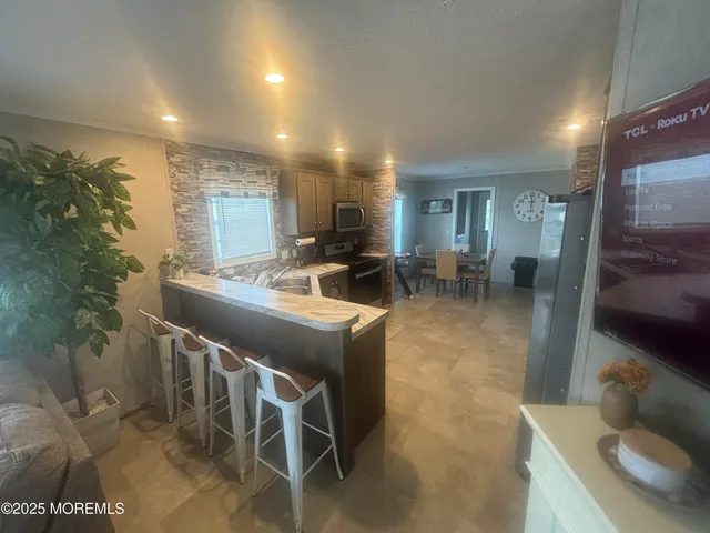 a dining room with furniture and a floor to ceiling window