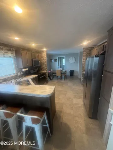 a kitchen with stainless steel appliances granite countertop a sink a stove and a refrigerator