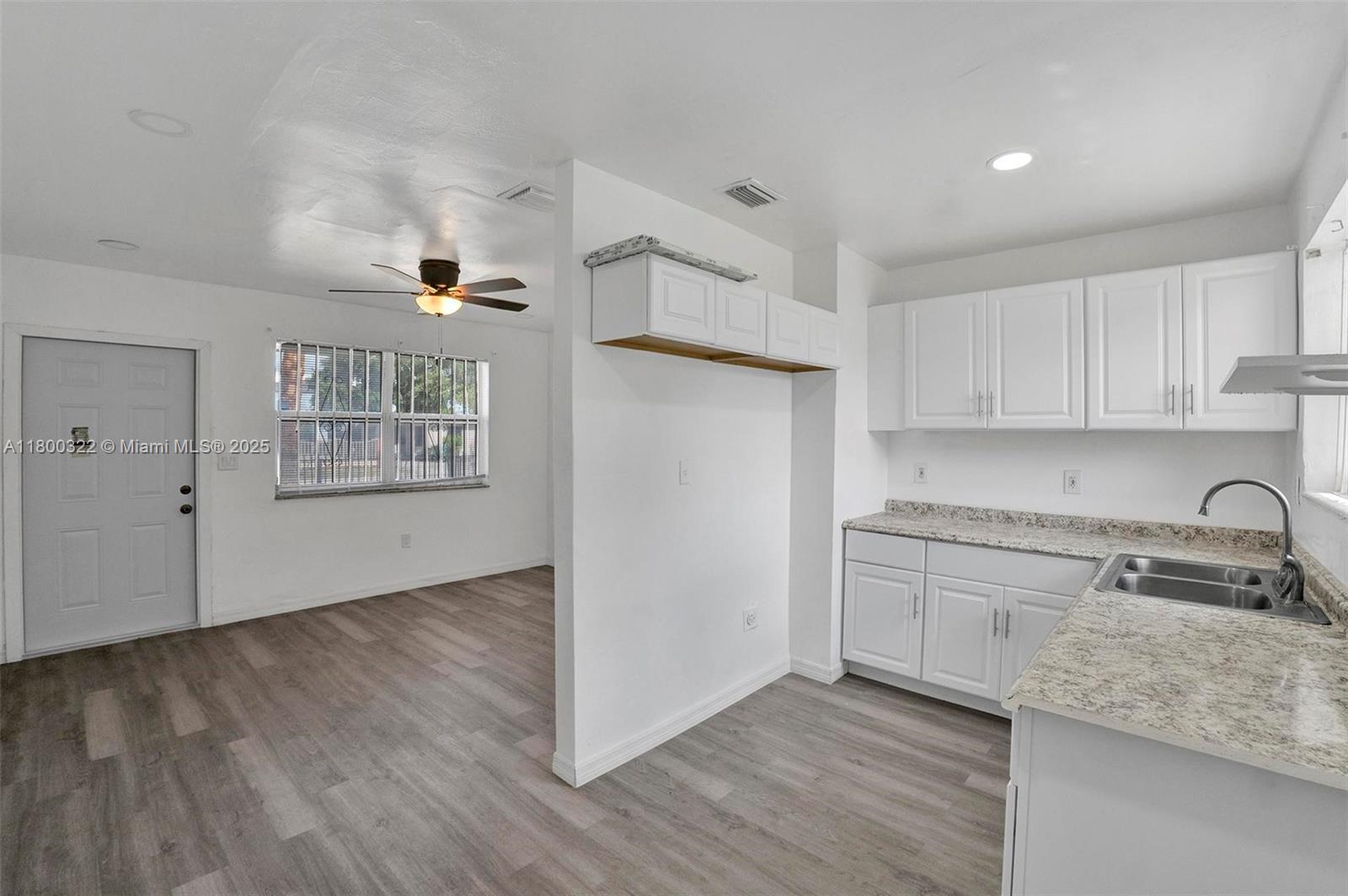 3051 Northwest 77th Street Miami, FL 33147 - Photo 23 of 44 a kitchen with granite countertop white cabinets and white appliances