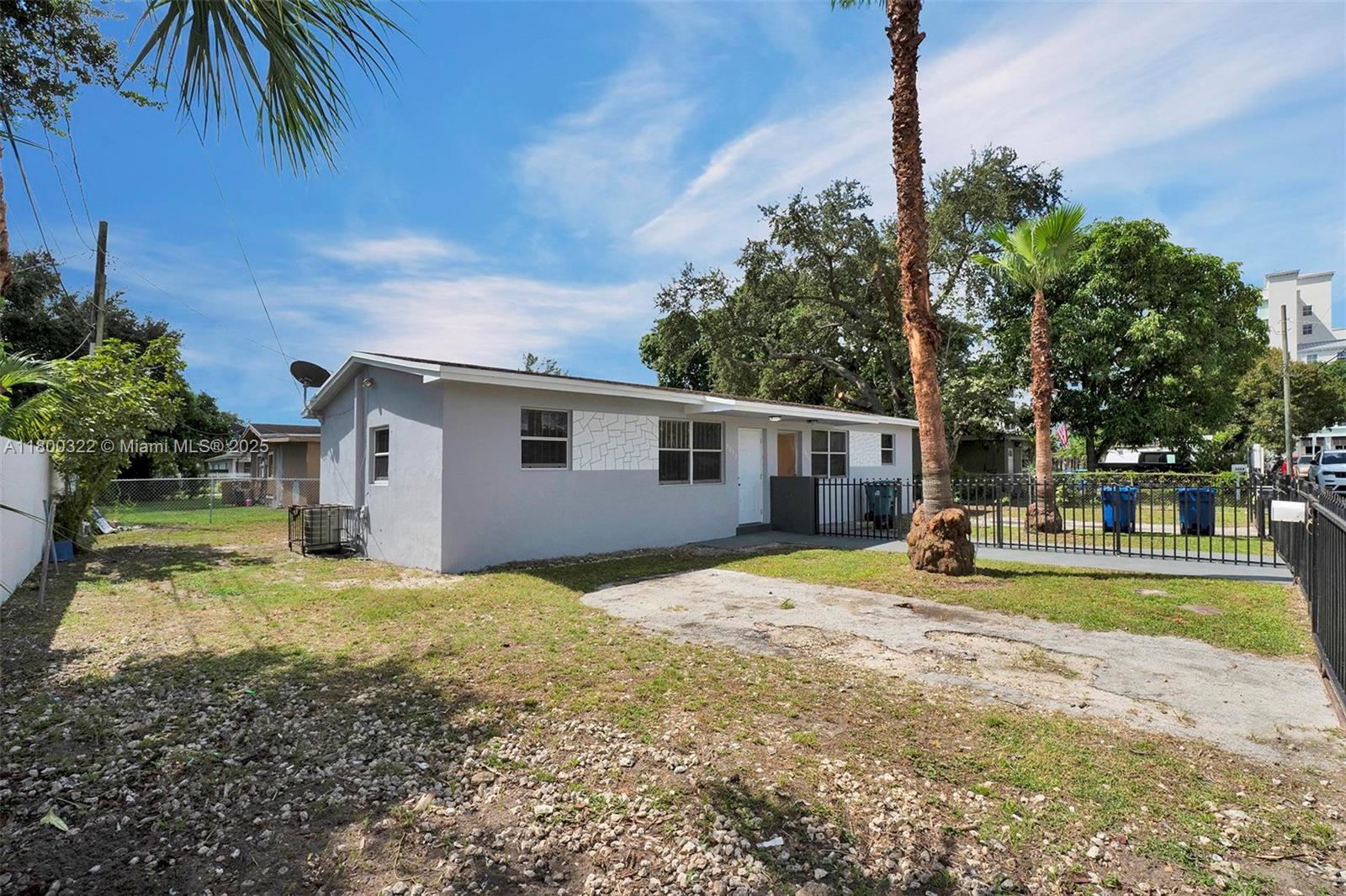 3051 Northwest 77th Street Miami, FL 33147 - Photo 25 of 44 a view of a house with a backyard and a tree