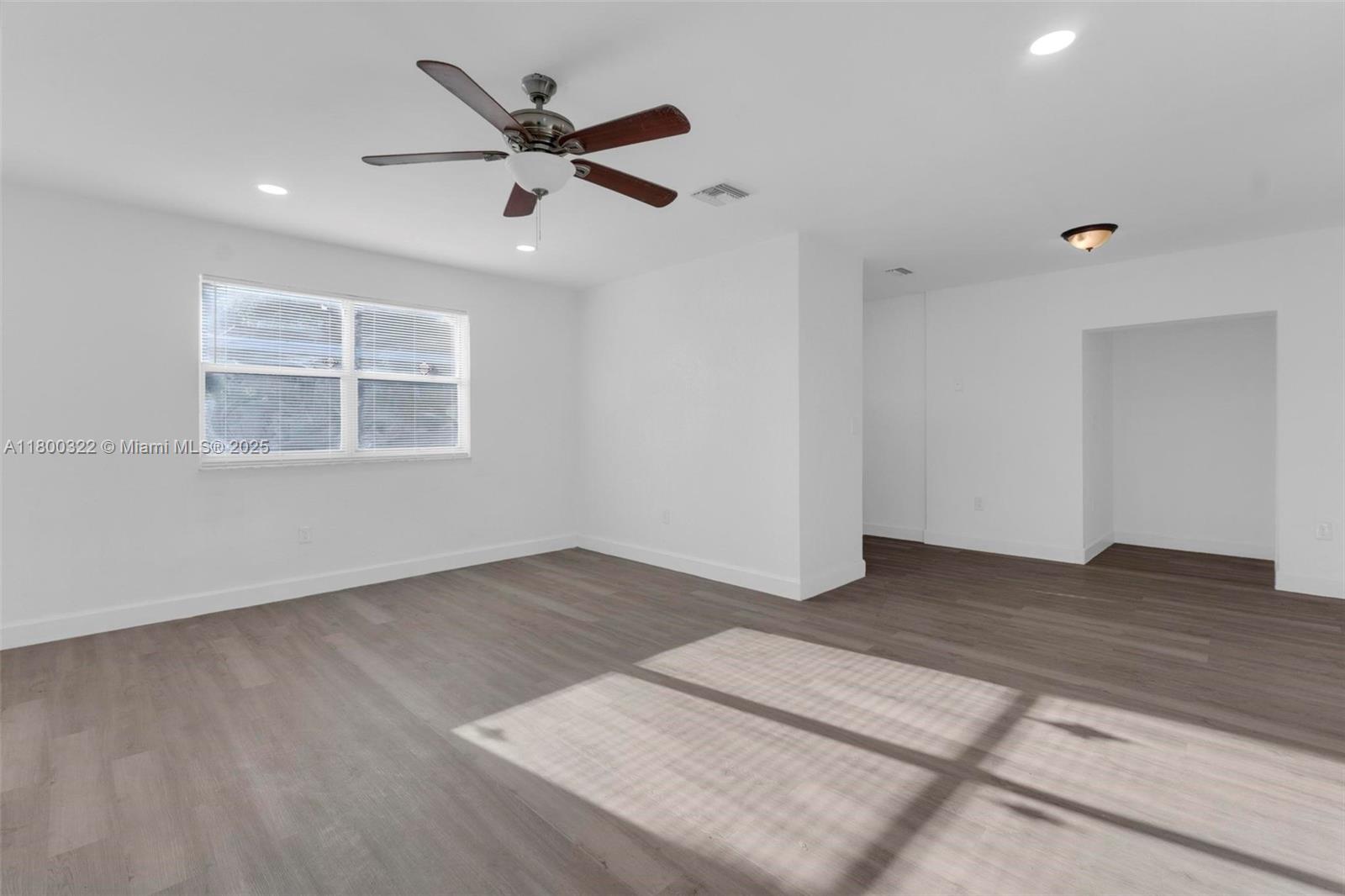 3051 Northwest 77th Street Miami, FL 33147 - Photo 37 of 44 an empty room with wooden floor fan and windows