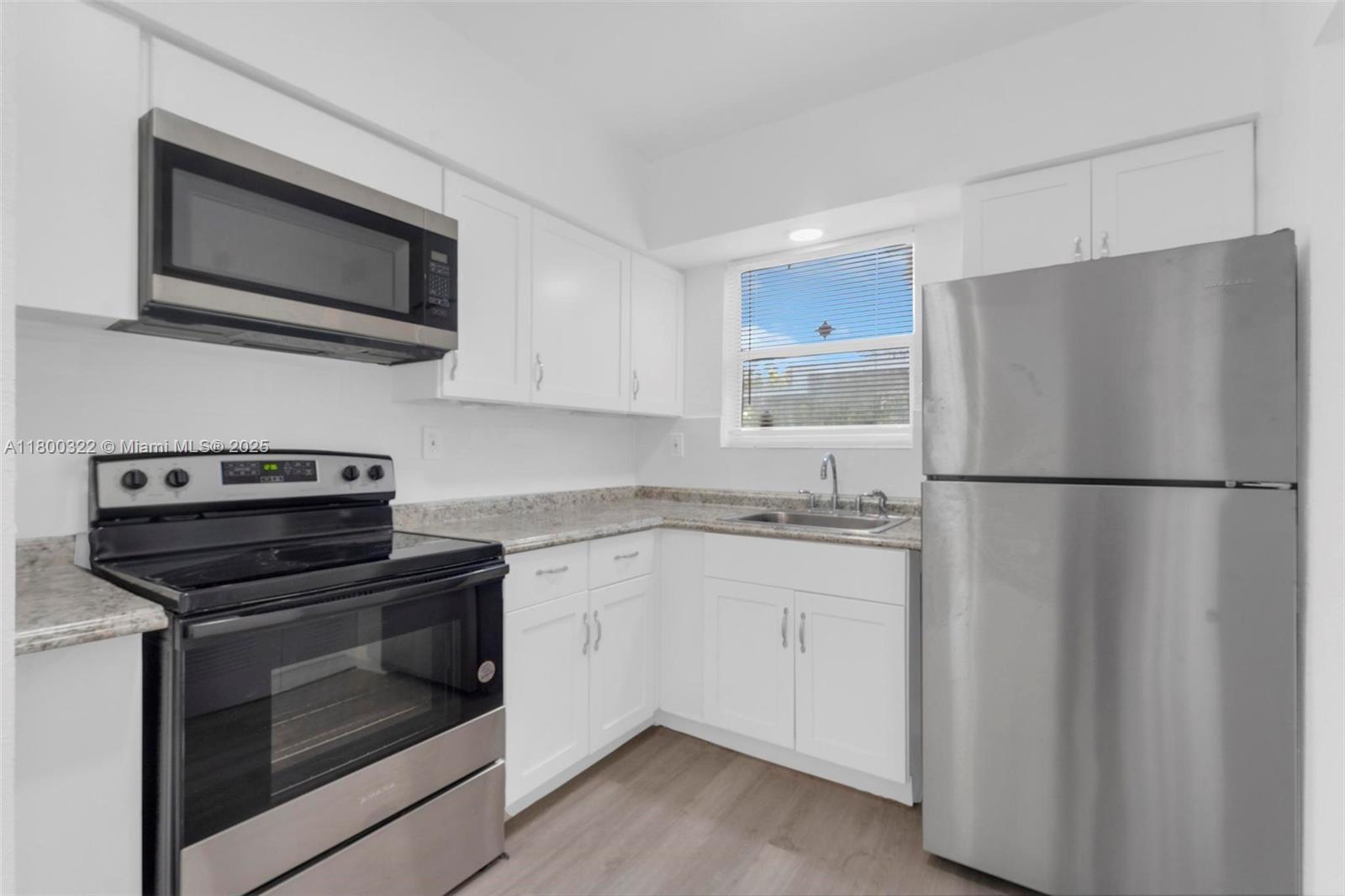 3051 Northwest 77th Street Miami, FL 33147 - Photo 44 of 44 a kitchen with stainless steel appliances granite countertop a refrigerator stove a sink and a microwave