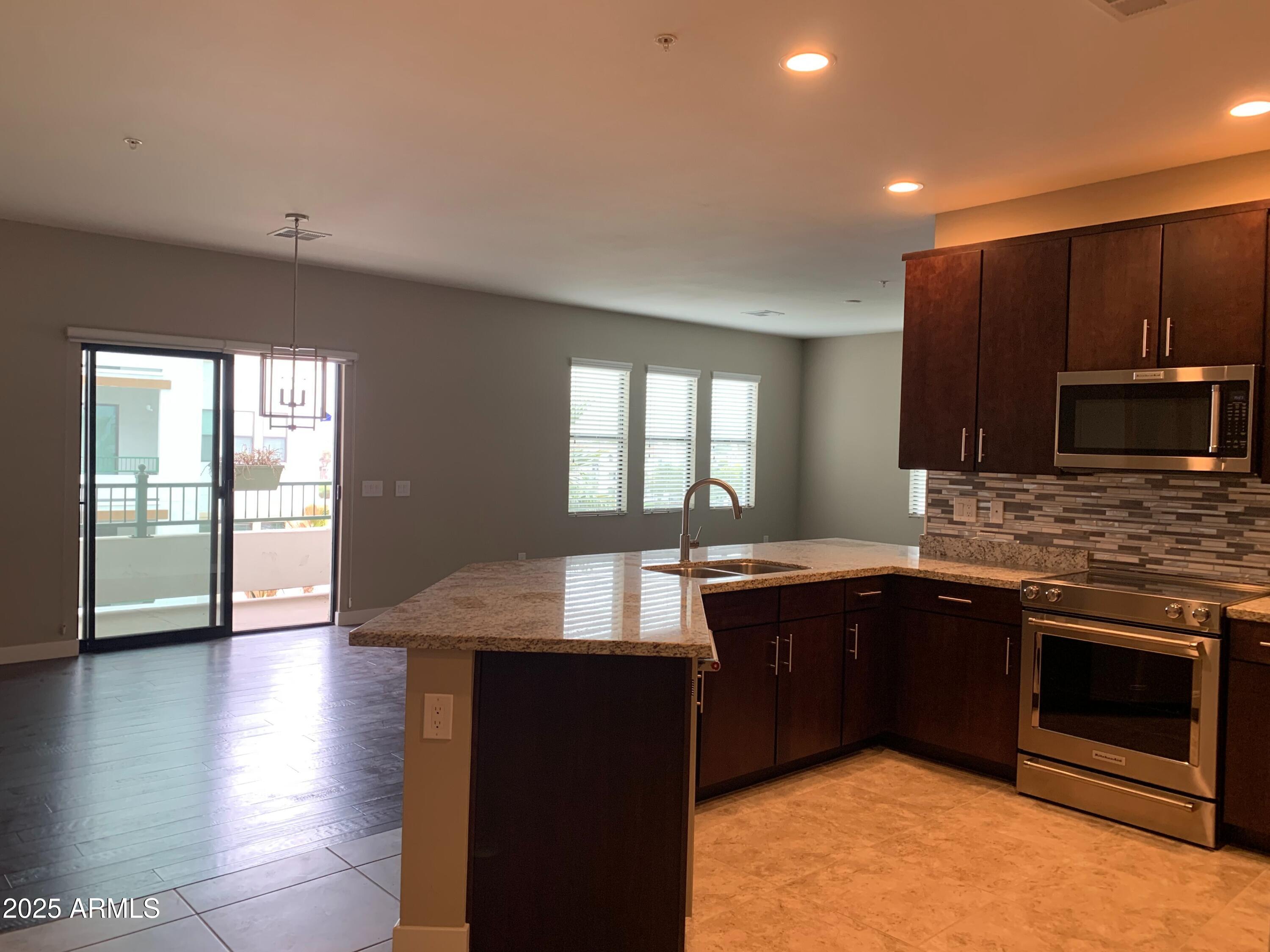 2511 West Queen Creek Road, Unit 326 Chandler, AZ 85248 - Photo 13 of 32 a kitchen with stainless steel appliances granite countertop wooden cabinets a sink and a stove