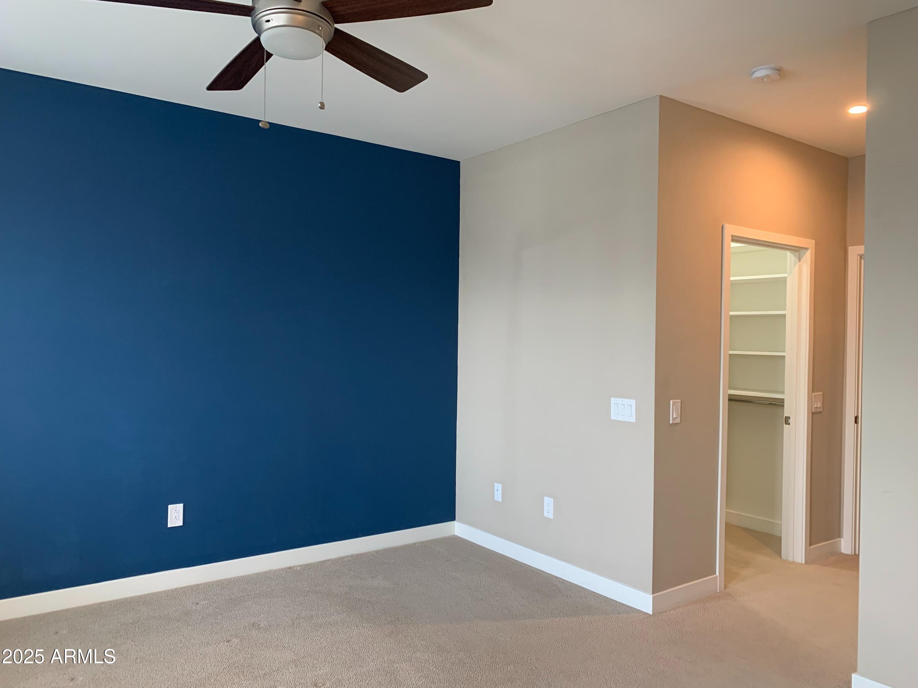 2511 West Queen Creek Road, Unit 326 Chandler, AZ 85248 - Photo 17 of 32 an empty room with a ceiling fan and carpet
