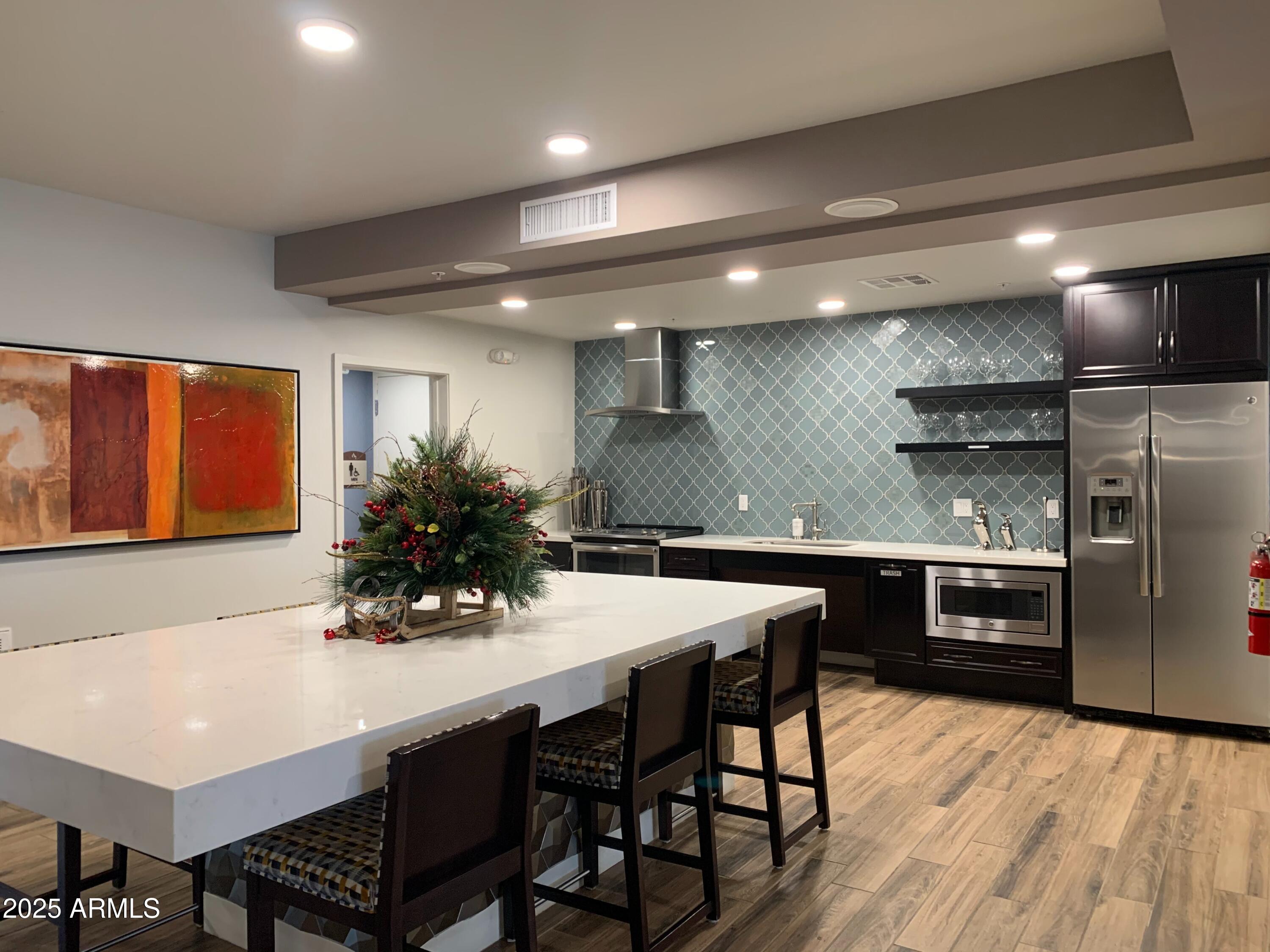 2511 West Queen Creek Road, Unit 326 Chandler, AZ 85248 - Photo 27 of 32 a kitchen with stainless steel appliances a dining table chairs and stove