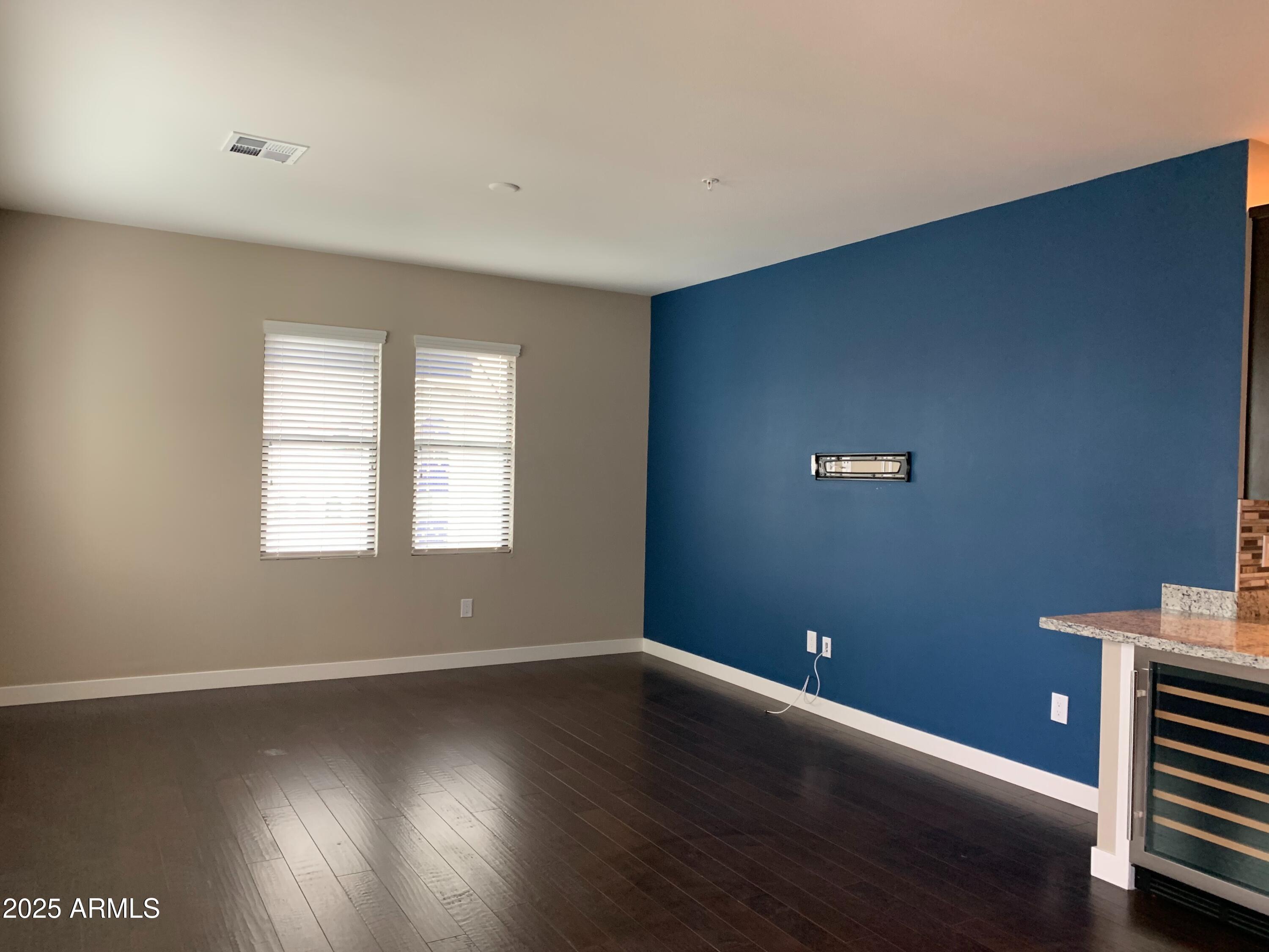 2511 West Queen Creek Road, Unit 326 Chandler, AZ 85248 - Photo 6 of 32 an empty room with wooden floor and windows