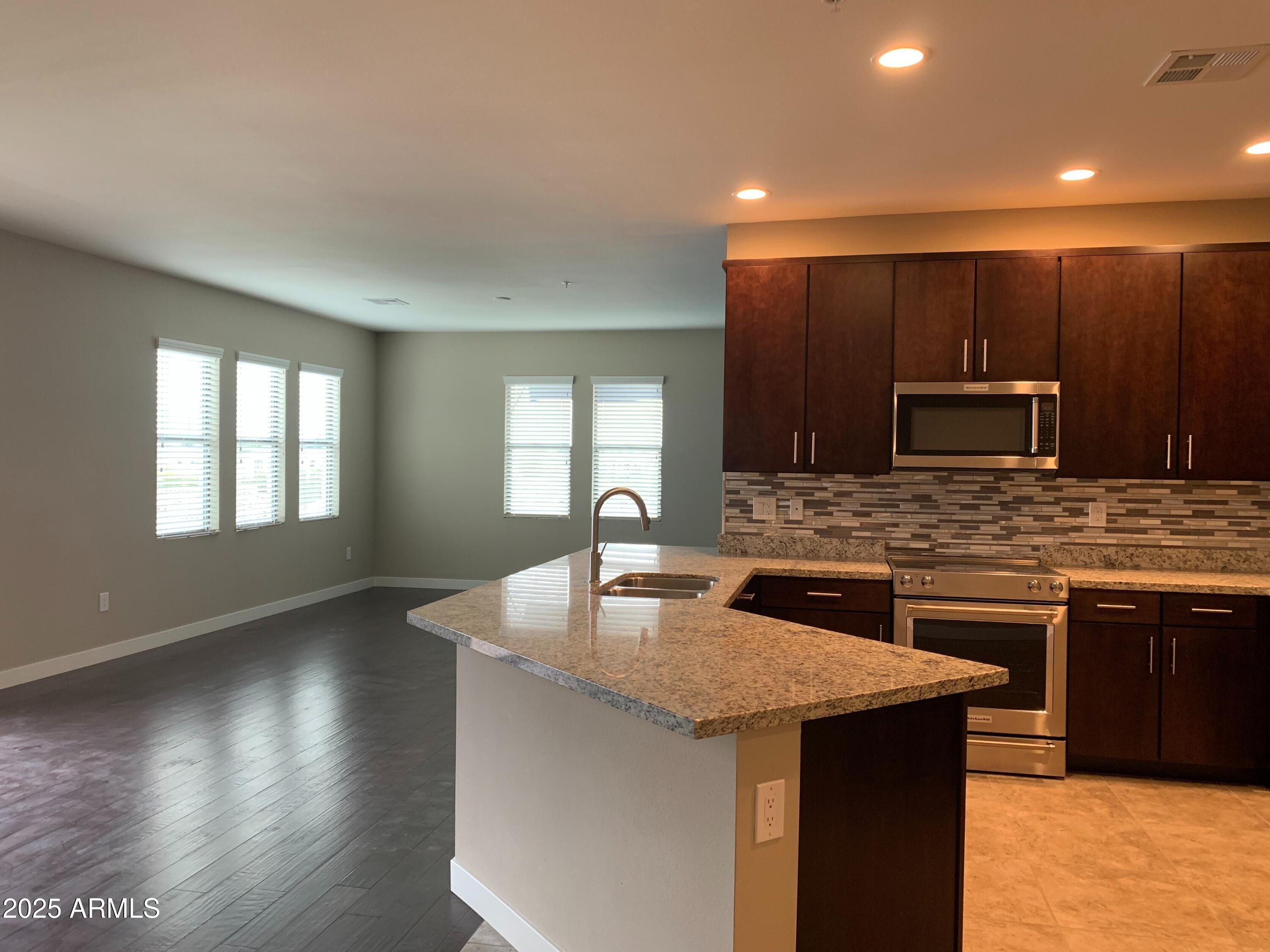 2511 West Queen Creek Road, Unit 326 Chandler, AZ 85248 - Photo 7 of 32 a kitchen with stainless steel appliances granite countertop a sink stove and cabinets