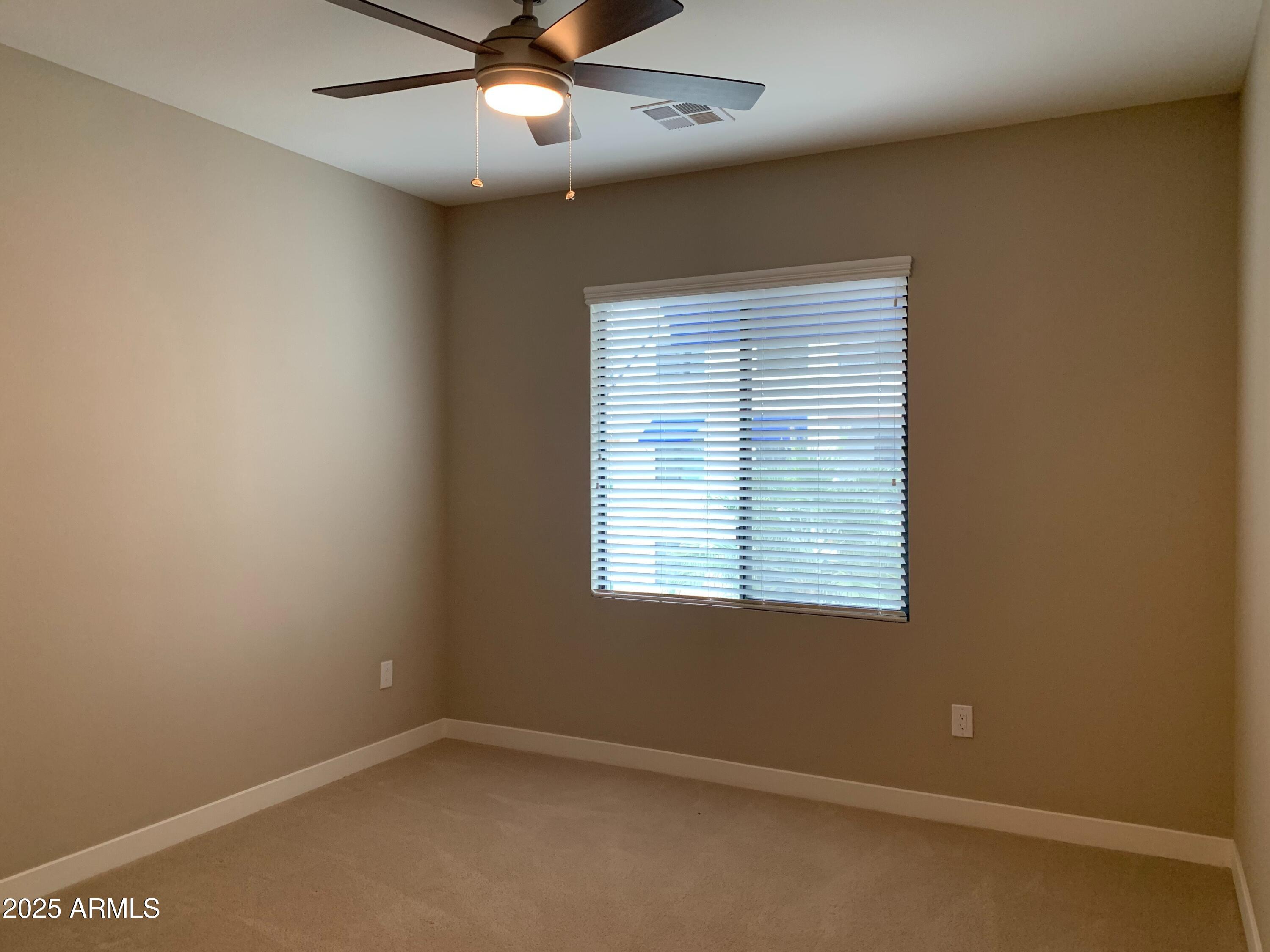 2511 West Queen Creek Road, Unit 326 Chandler, AZ 85248 - Photo 8 of 32 an empty room with a window and a fan