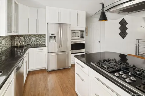 a kitchen with stainless steel appliances granite countertop a refrigerator and a stove top oven