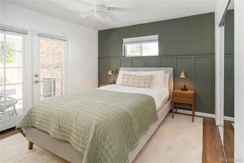 a bedroom with a bed and large windows