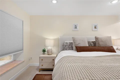 a bedroom with a white bed and a dresser