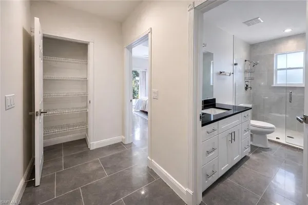 a bathroom with a granite countertop sink a toilet and shower