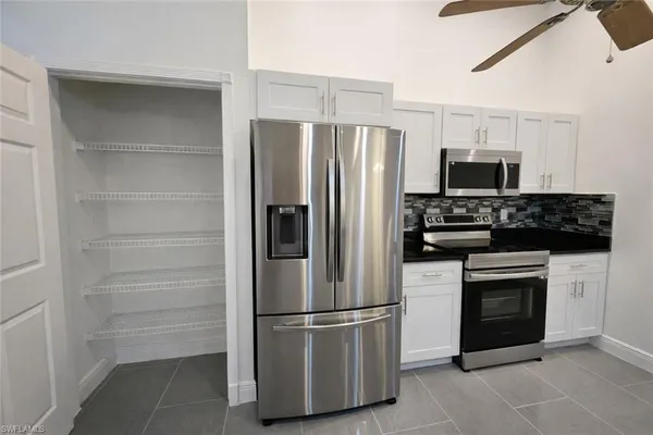 a view of a kitchen with cabinets and a refrigerator