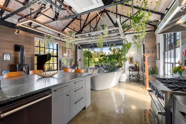 a open kitchen with stainless steel appliances granite countertop a sink a stove and a wooden floors