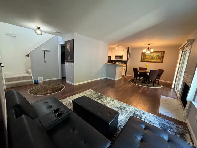 a living room with dining table and chairs with wooden floor