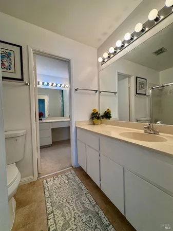 a bedroom with a bed a mirror on dresser and a window