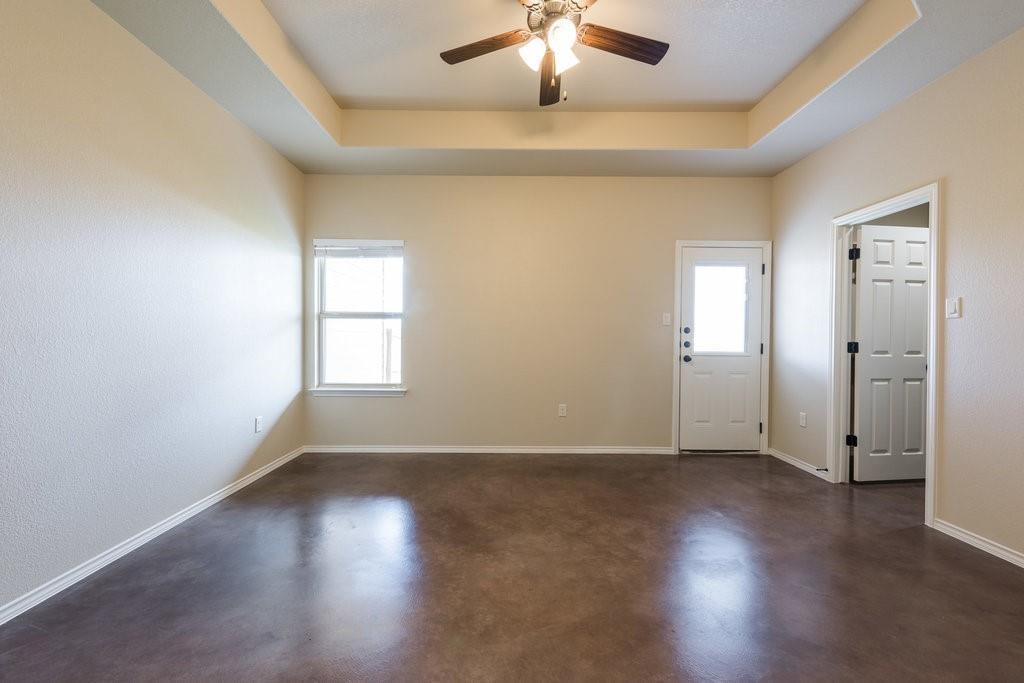 491 Jack Rabbit Lane, Unit A Buda, TX 78610 - Photo 10 of 22 A versatile living space with a classic ceiling fan and light-reflecting flooring.