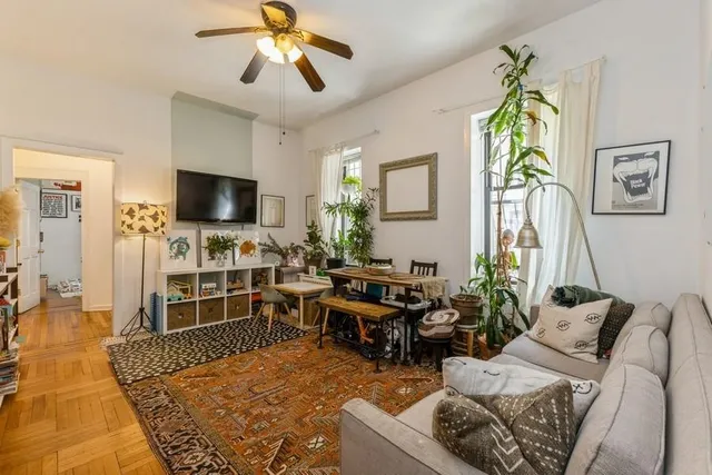 a living room with furniture a flat screen tv and a rug