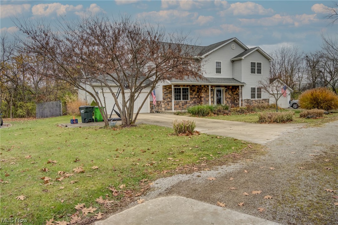View of property featuring a garage and a front lawn