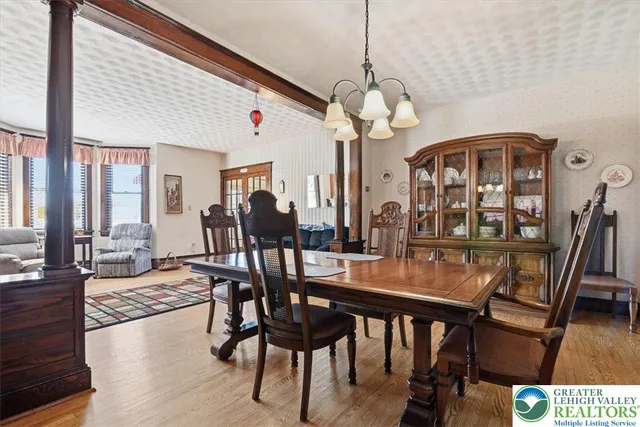 a view of a dining room and livingroom with furniture wooden floor a chandelier