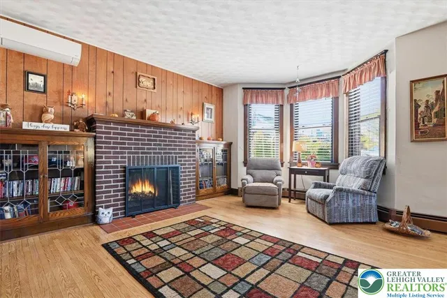 a living room with furniture a rug fireplace and a window