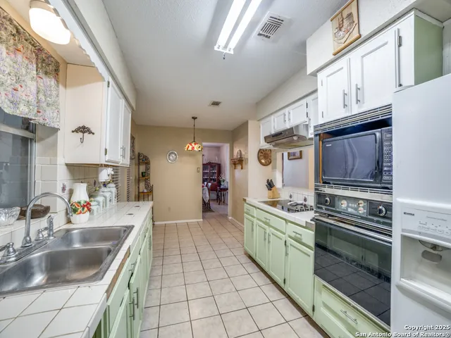 a kitchen with stainless steel appliances granite countertop a sink and a stove