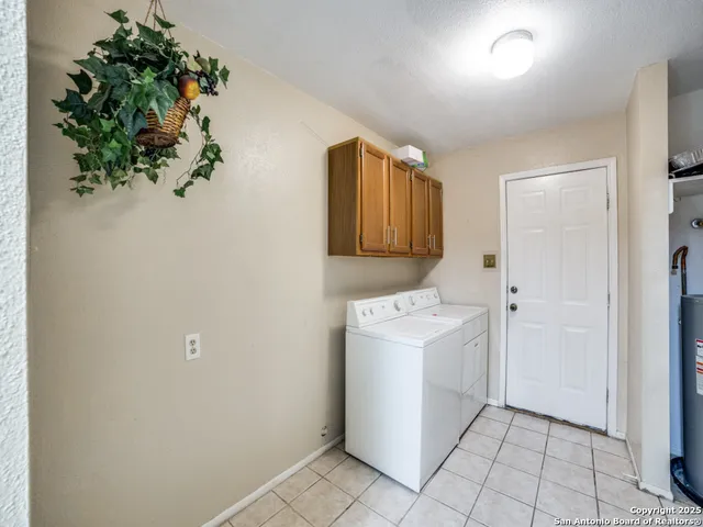a utility room with cabinets washer and dryer