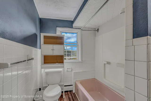 a bathroom with a toilet and a shower
