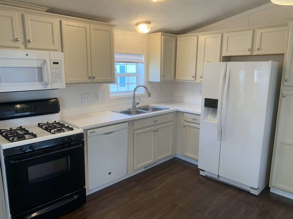 557 Southwest Cutoff, Unit 38 Worcester, MA 01607 - Photo 7 of 20 a kitchen with white cabinets and white appliances